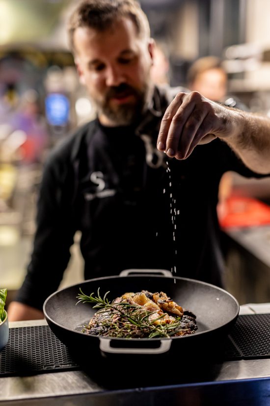 Chefcock stoked throws salt over dish